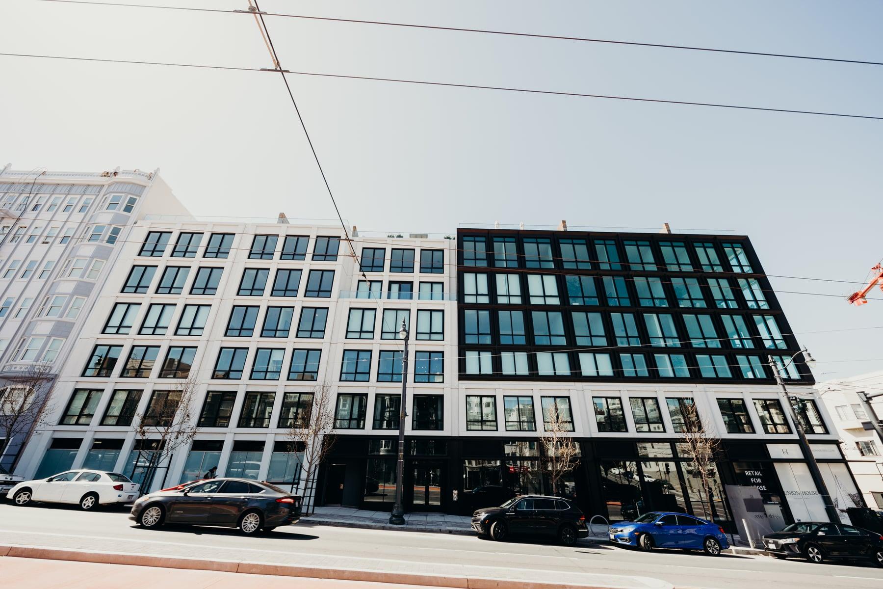 Street view of the 2465 Van Ness facade, with rows of dark-framed windows above a ground-floor storefront
