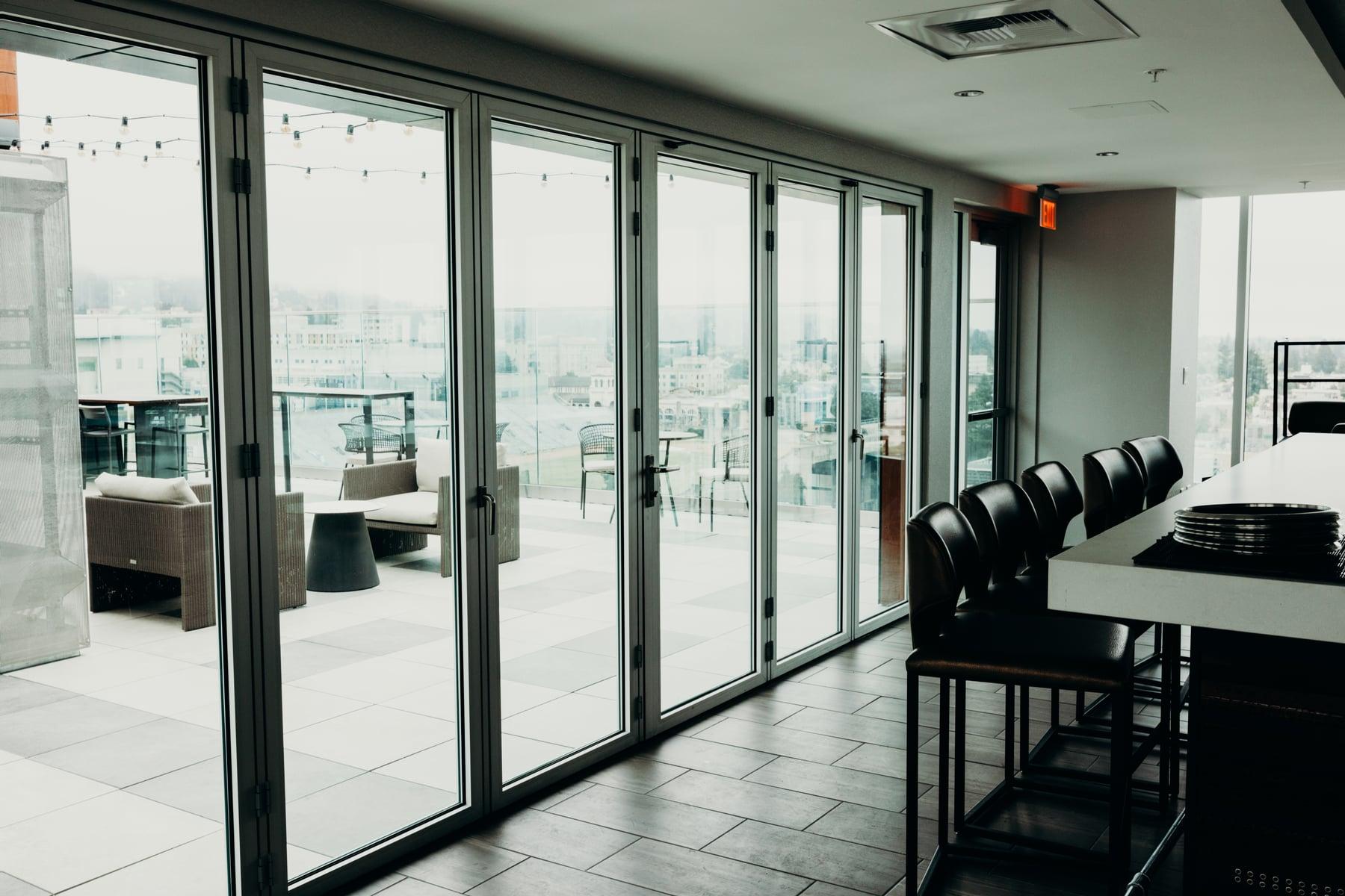 Interior room with floor-to-ceiling folding glass doors opening onto a rooftop terrace