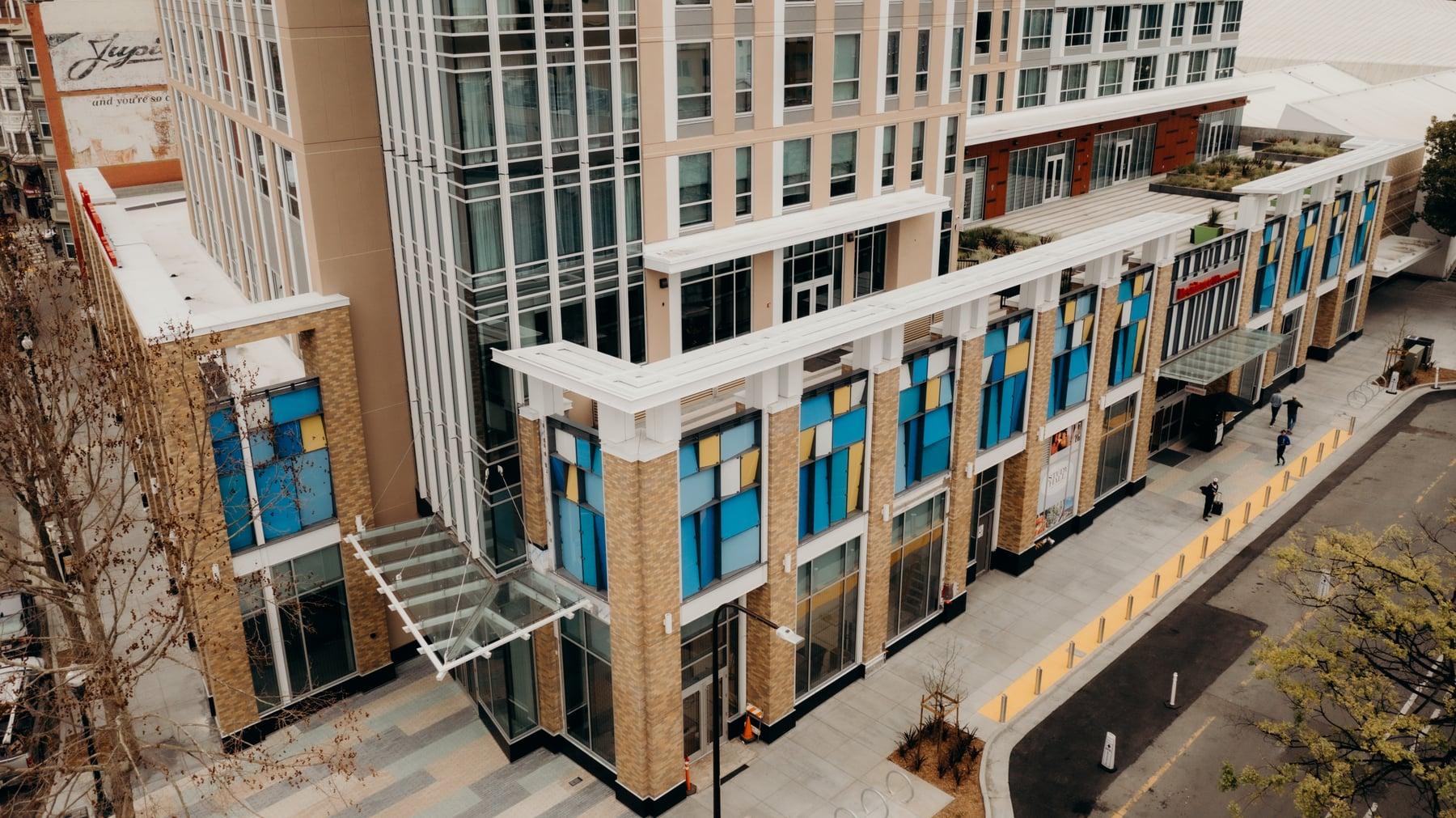 Aerial view of the Residence Inn's lower floors and street frontage, with blue and yellow glazing along the base