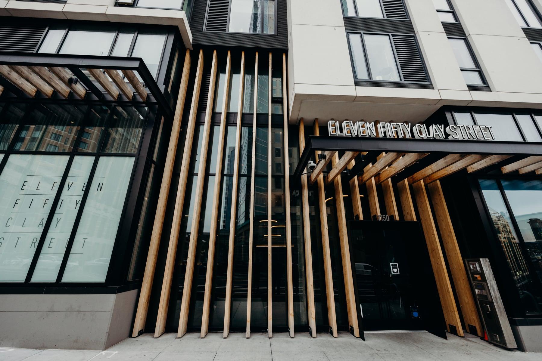 Wood fin screen and glazed storefront at the entrance, with the Eleven Fifty Clay Street sign above