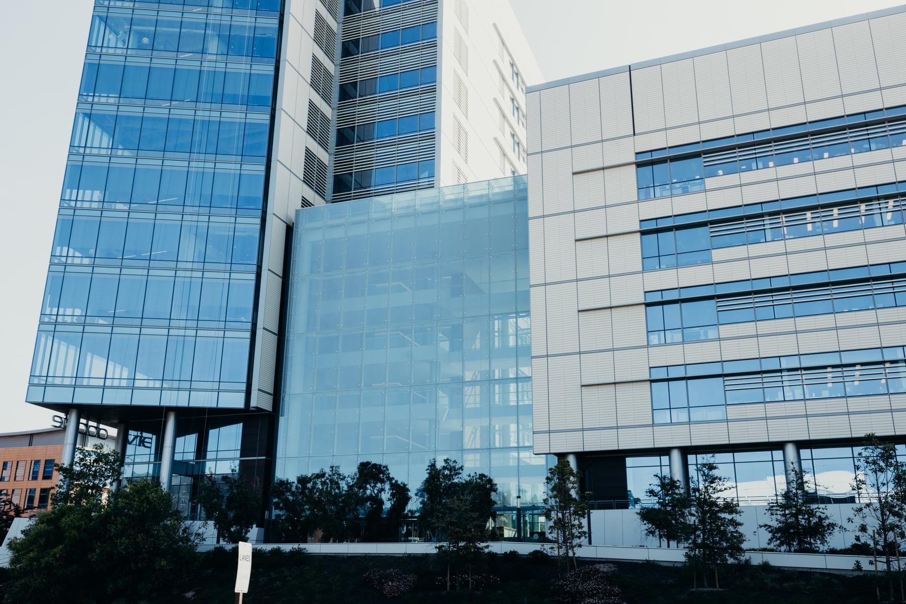 Gateway building exterior with a blue glass curtain wall tower, a glass-fronted section and a paneled wing with horizontal windows