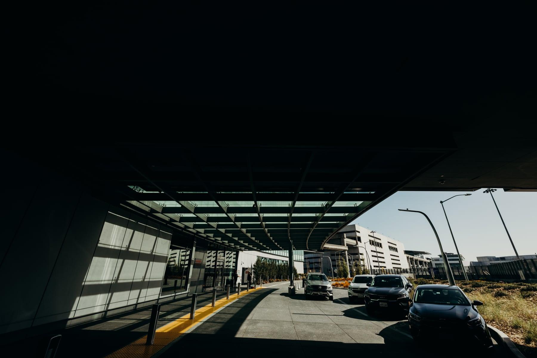 Wide view under the Grand Hyatt glass canopy toward the entrance drive