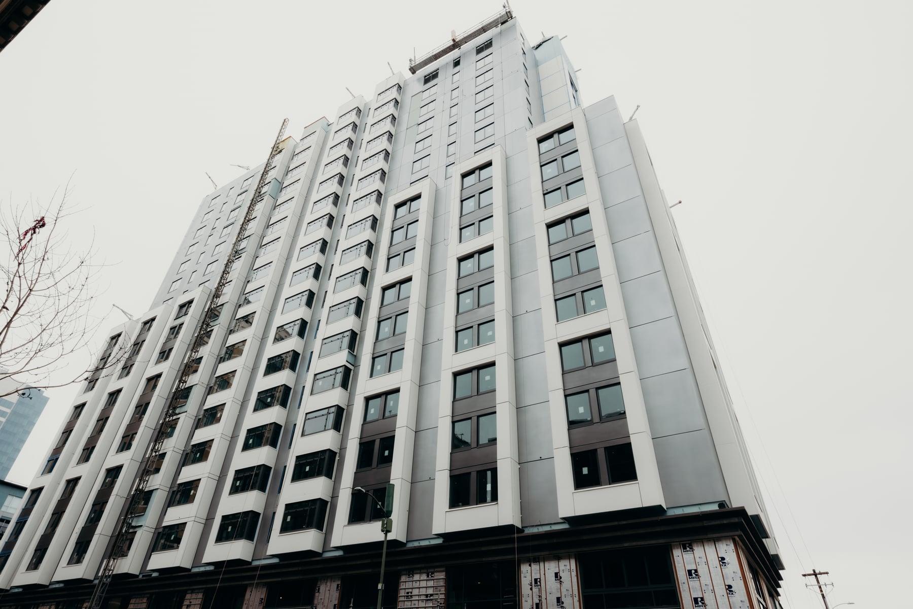 Oakland Marriott hotel tower from the street, with light gray panels between rows of dark-framed windows