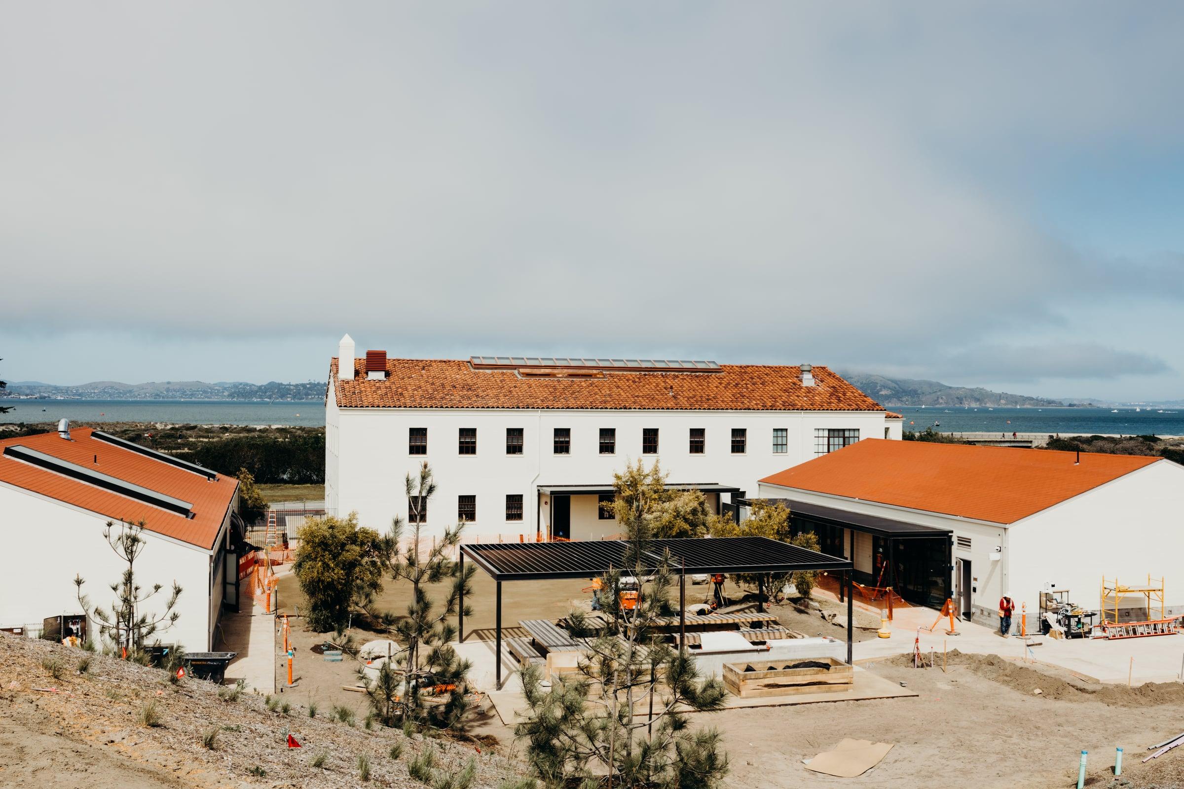 Historic Presidio buildings with red tile roofs and San Francisco Bay in the background