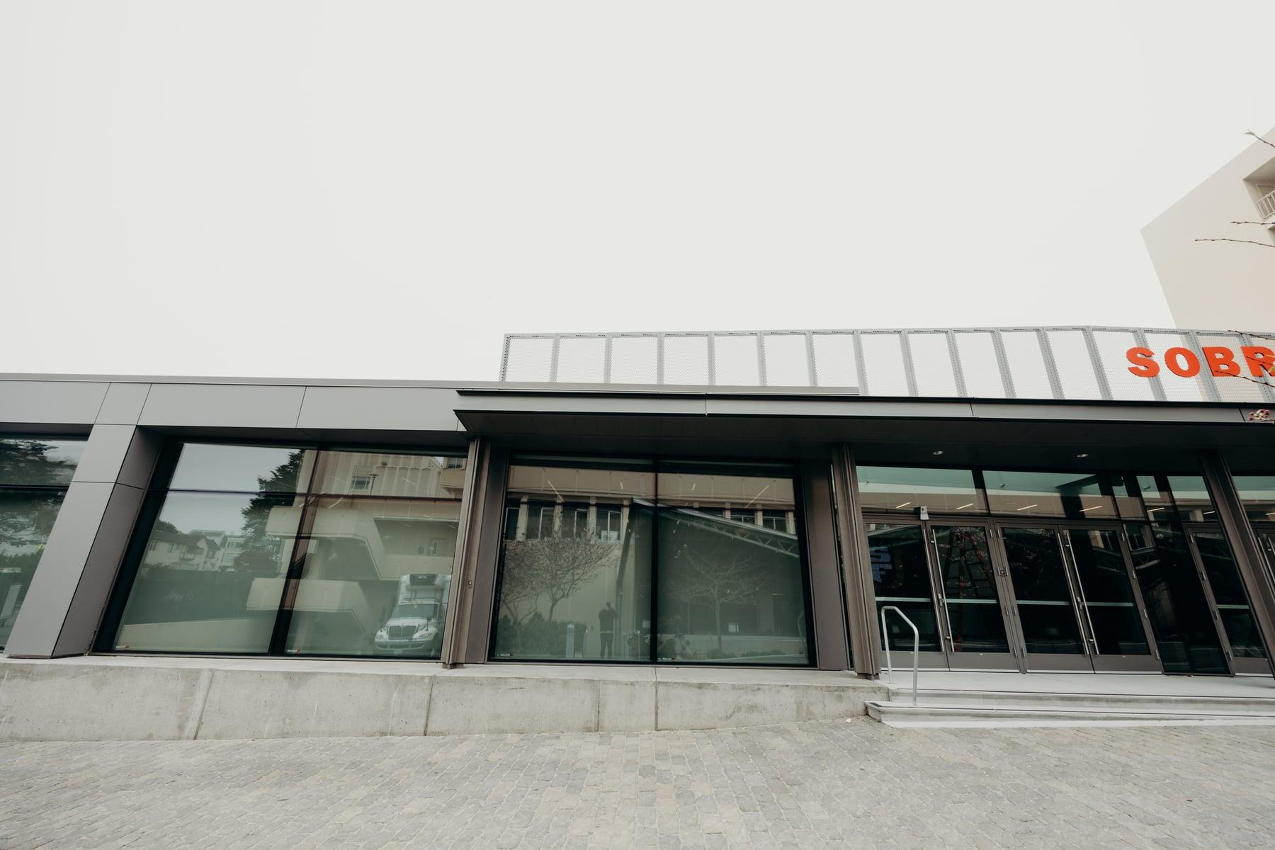 Glass storefront and entry doors along the front of the Sobrato Center at USF War Memorial Gymnasium