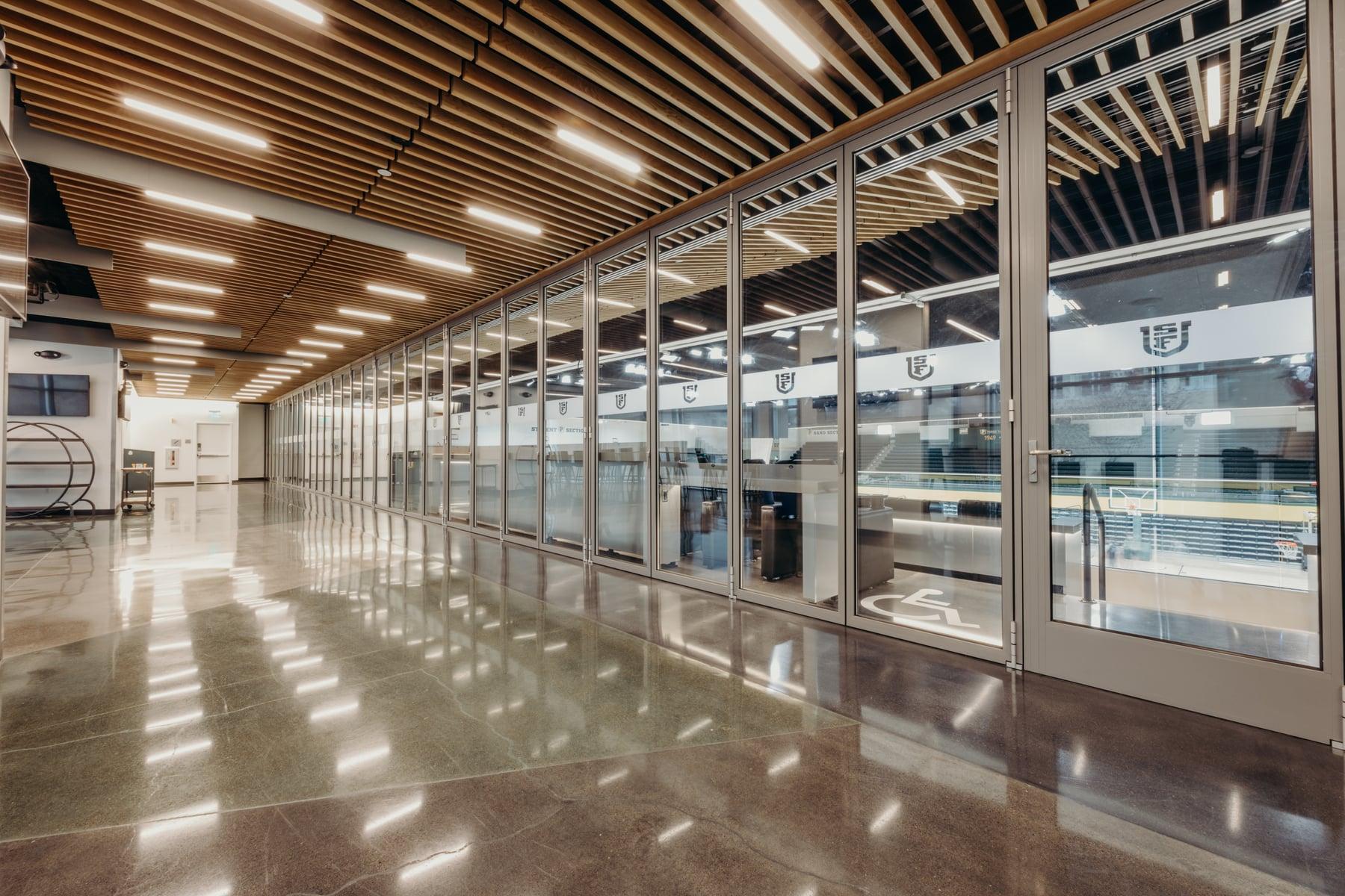 Long run of NanaWall folding glass panels dividing a concourse from the gymnasium at USF's War Memorial Gymnasium