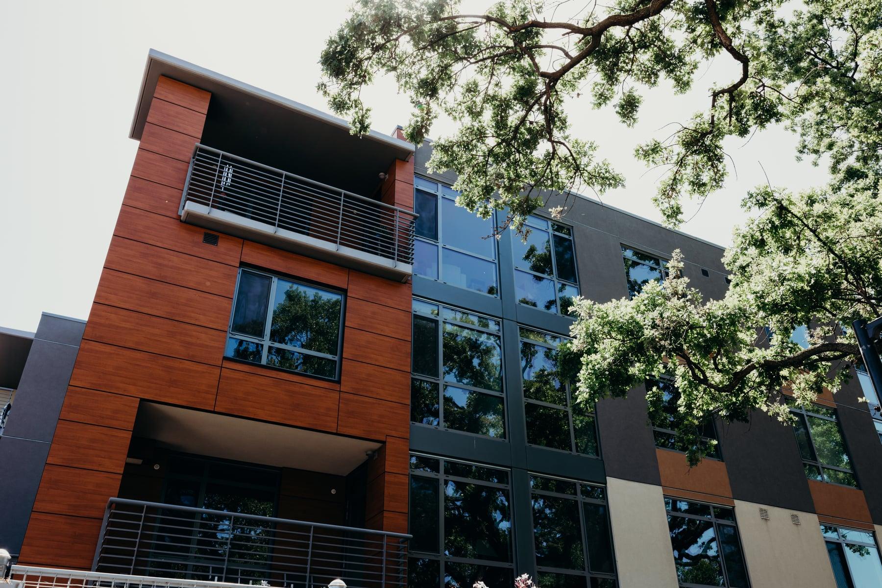Viamonte in Walnut Creek, CA, showing the building's windows and glazed bays set in its orange and charcoal exterior panels