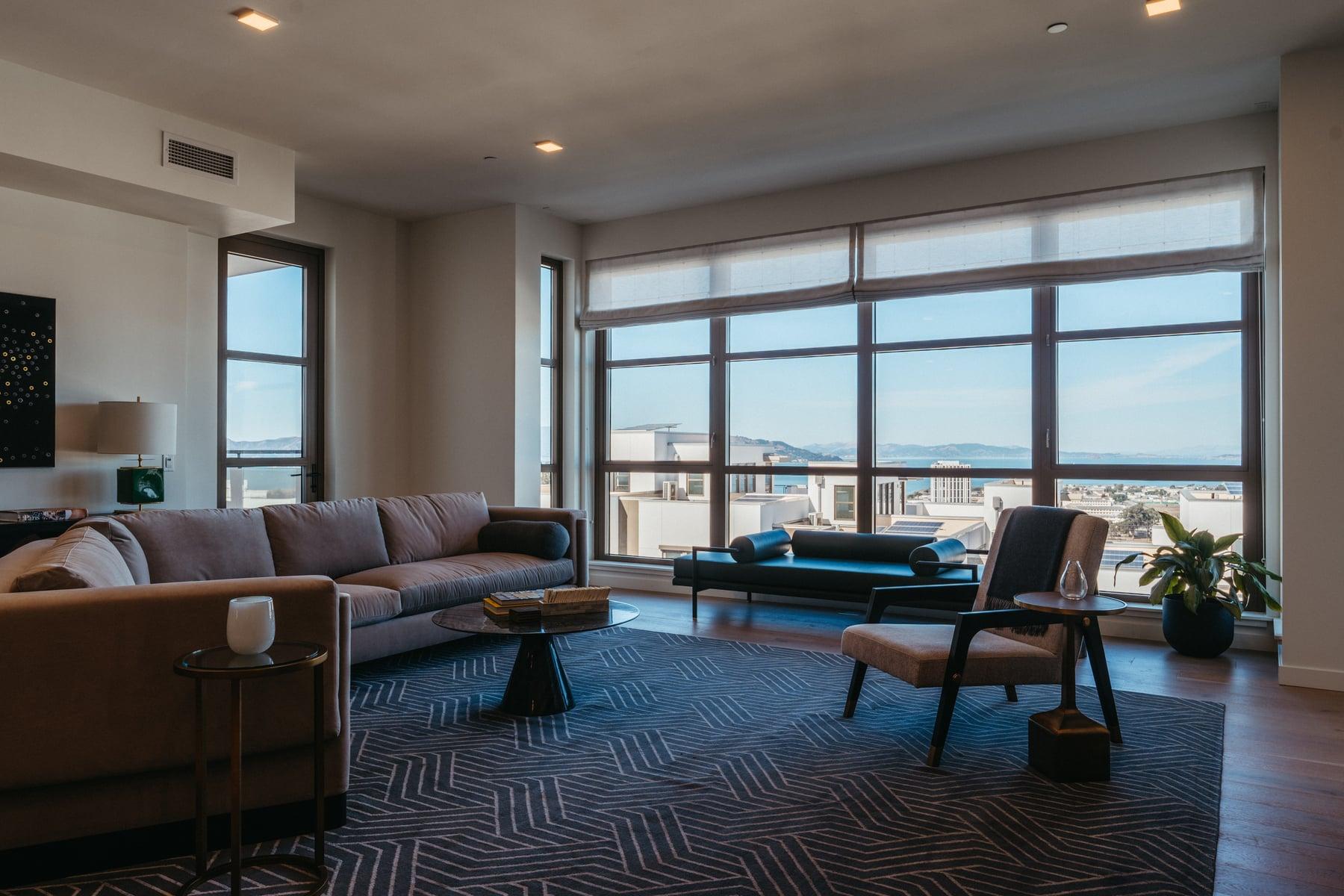 Furnished living room with large black-framed windows and a view over the water