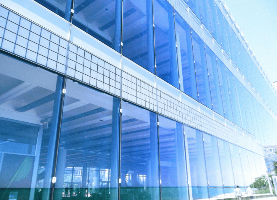 Architectural marvel of a modern glazed skyscraper reflecting daylight against a clear sky.