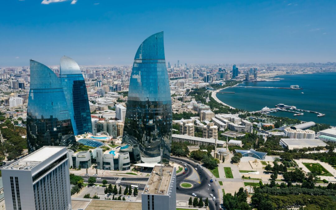 Aerial view of high-rise buildings with reflective glass facades demonstrating advanced glazing in an urban coastal cityscape.