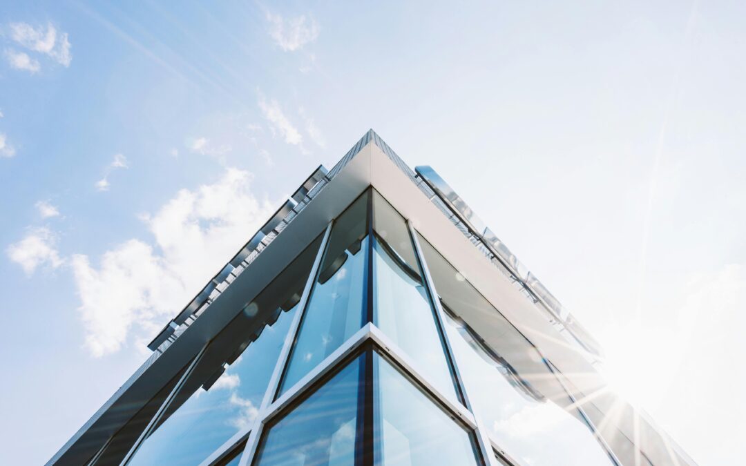 Modern glass building facade with sun reflecting off corner glazing—ideal example of architectural metal and glazing design in senior living facilities.